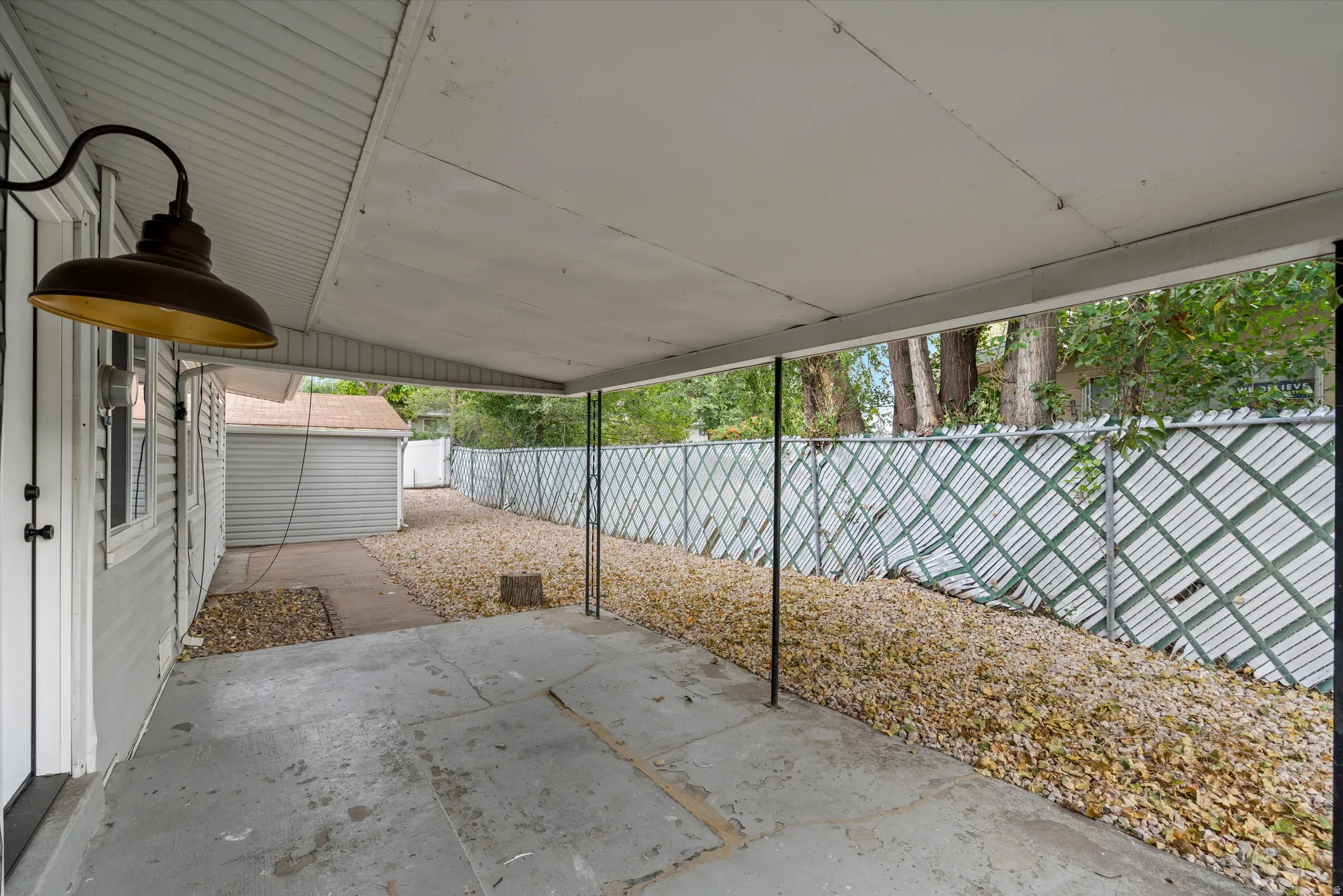 Covered concrete patio with an industrial-style light fixture