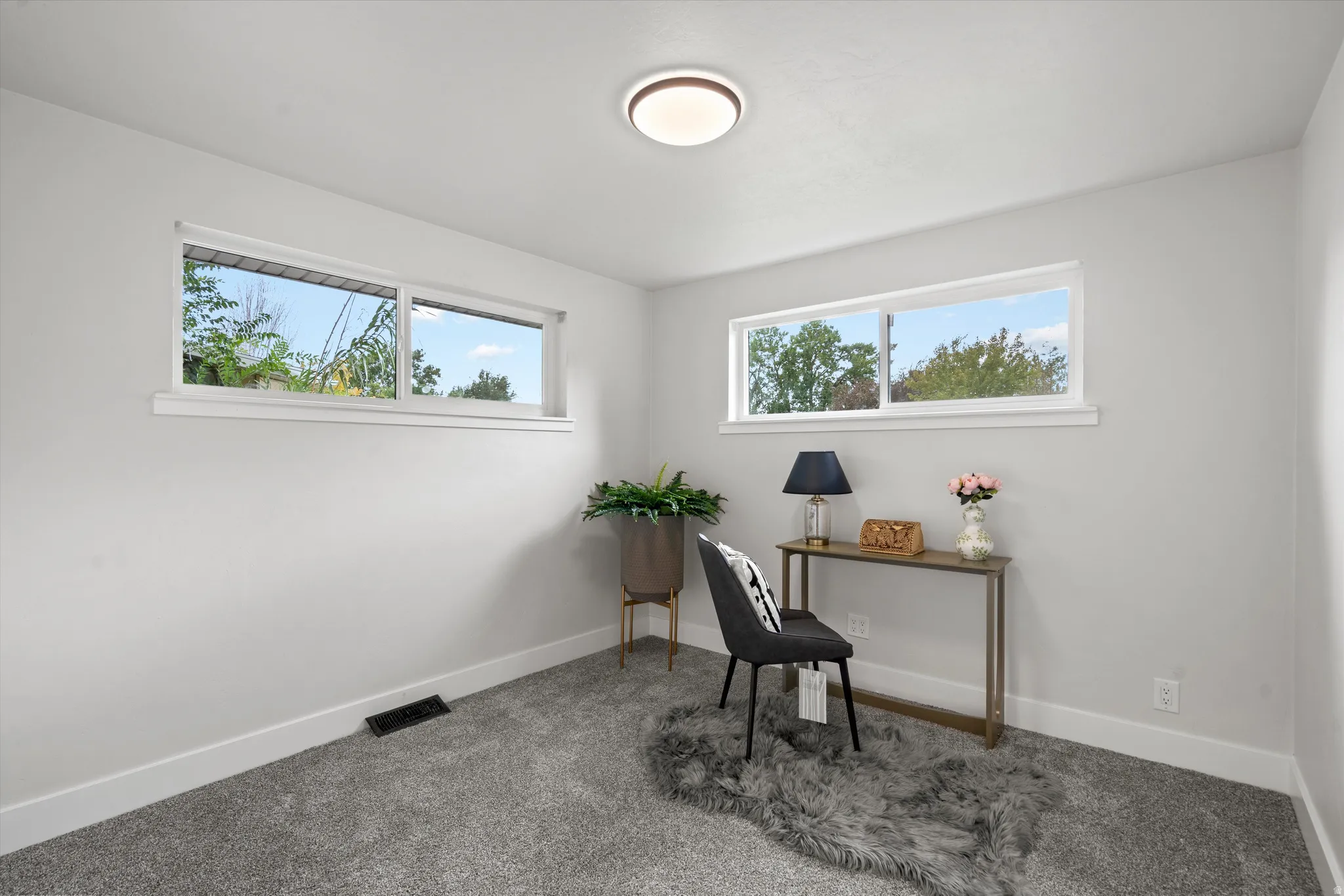 Light gray wall paint, white trim, rectangular windows, and a flush mount ceiling light