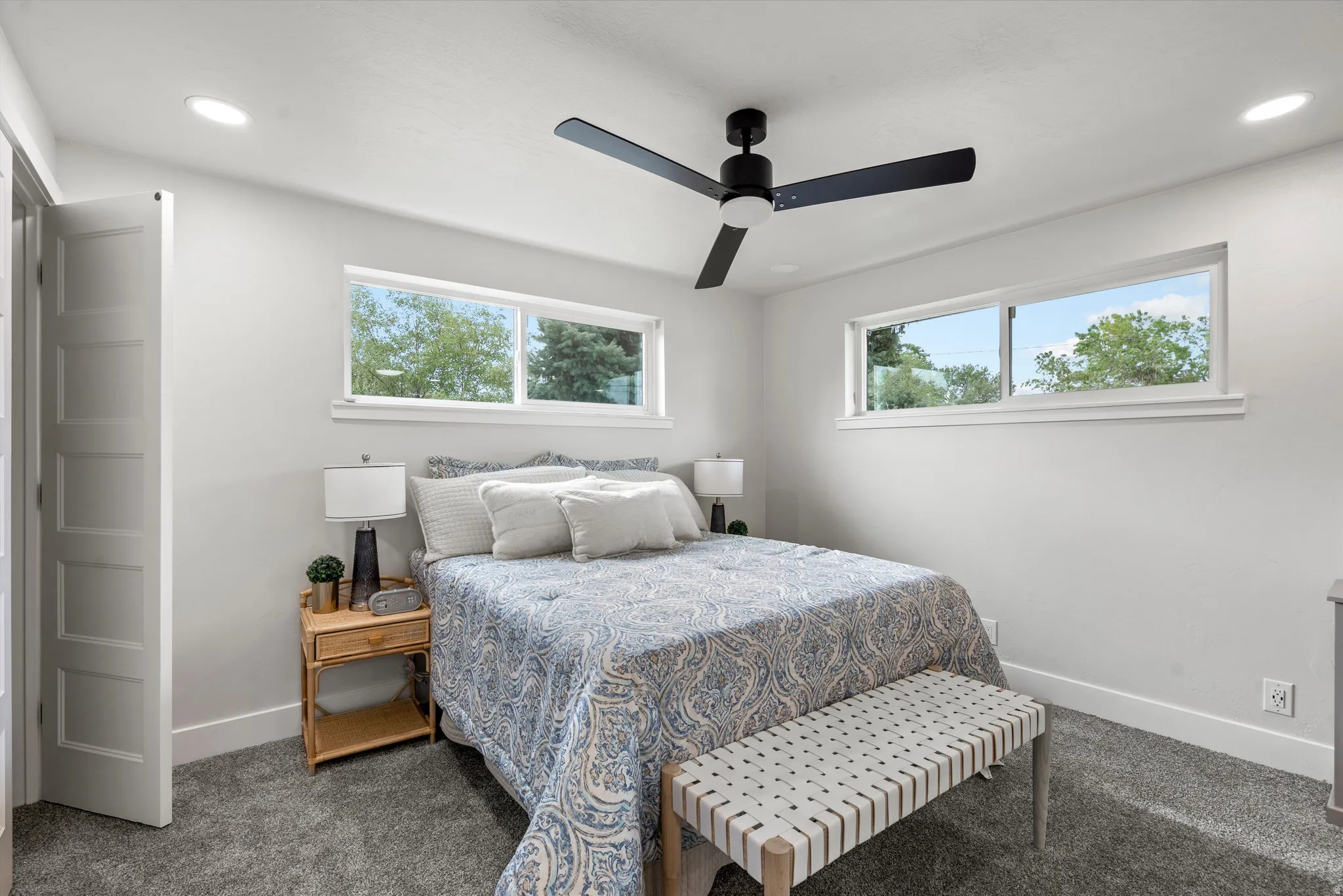 Recessed lighting, ceiling fan, white walls, carpet flooring, and dual horizontal windows