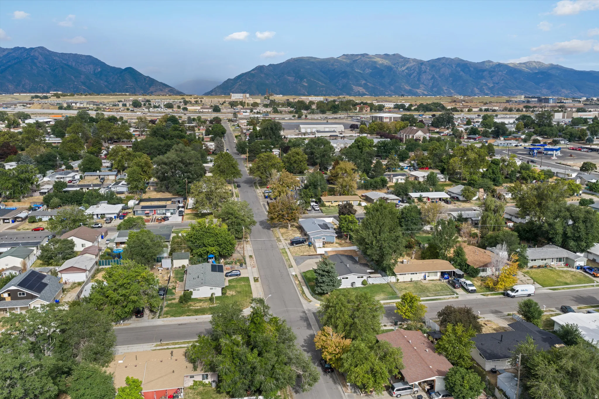 Expansive neighborhood setting with mature trees and mountain scenery