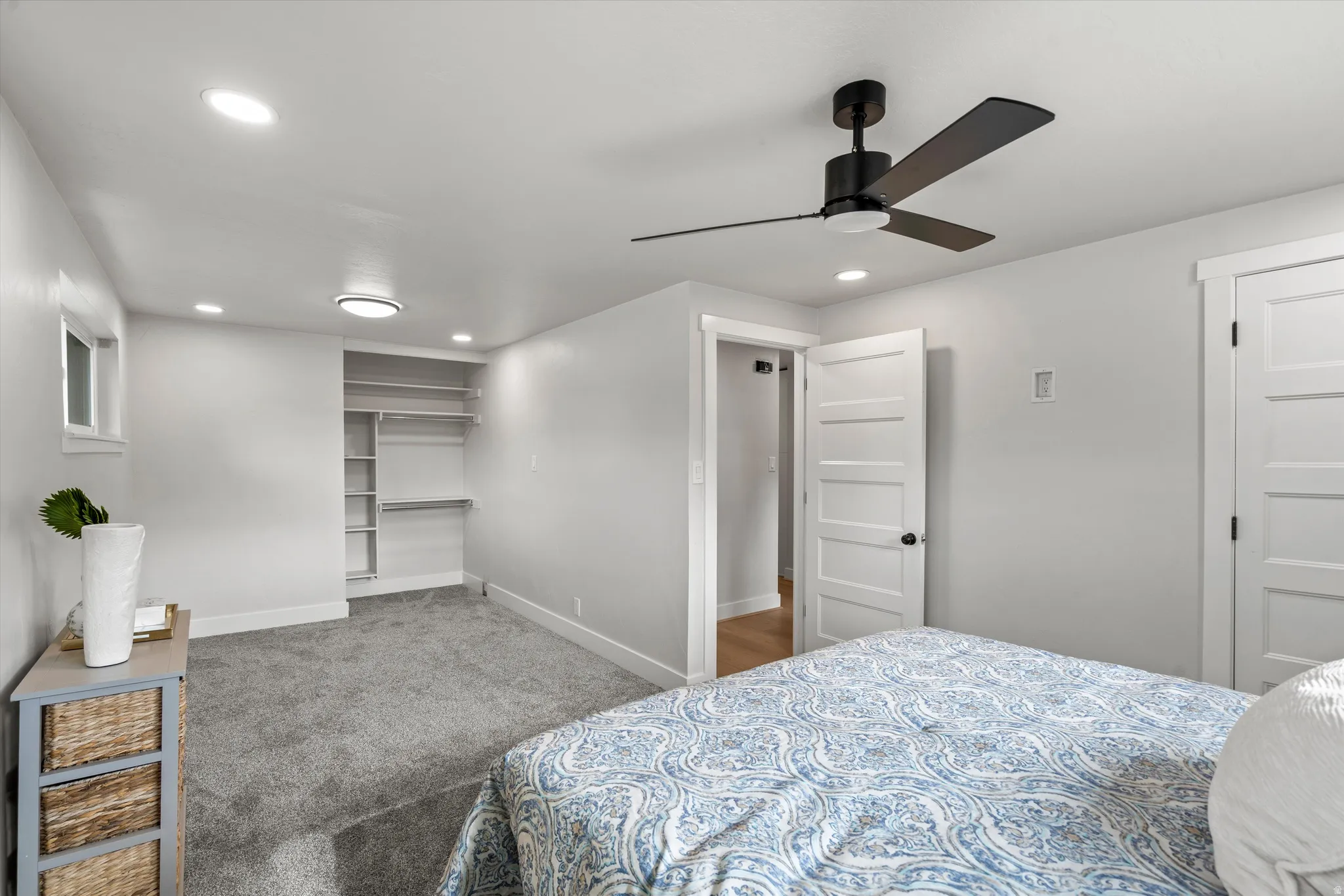 Recessed lighting, ceiling fan with integrated light, carpeted flooring, built-in closet shelving, and a multi-panel interior door