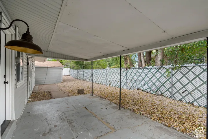 Covered concrete patio with an industrial-style light fixture