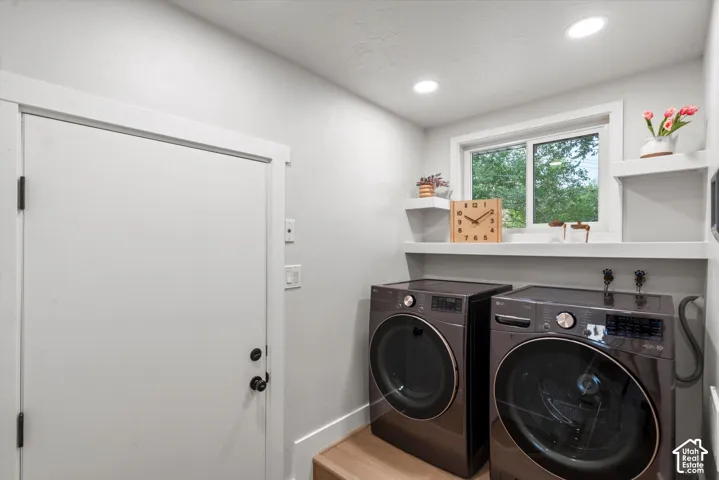 Laundry area featuring a window, built-in shelving, recessed lighting, and wood-finish flooring