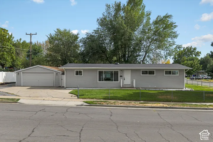 Single-story residence featuring light gray siding, a dark gray shingle roof, and an attached two-car garage