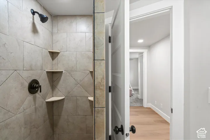 Tiled shower with corner shelves, oil-rubbed bronze fixtures, and glass enclosure