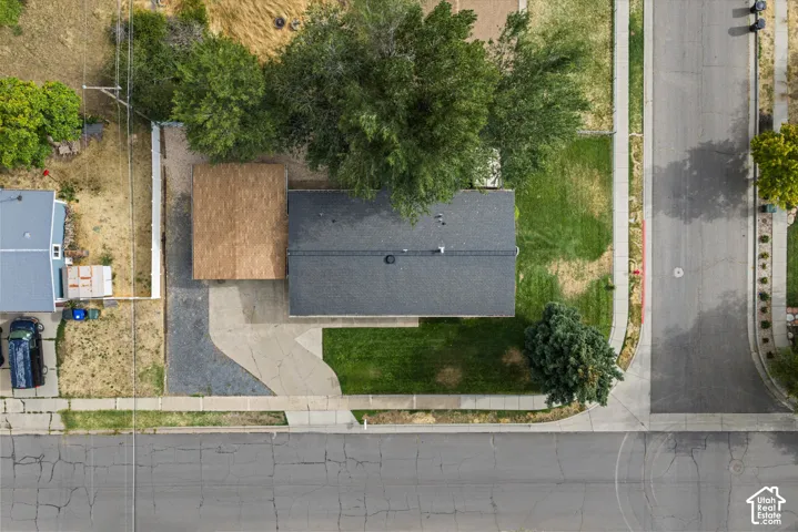 Property with a dark shingle roof, a light-colored wood-finish roof over an attached structure, and a concrete driveway
