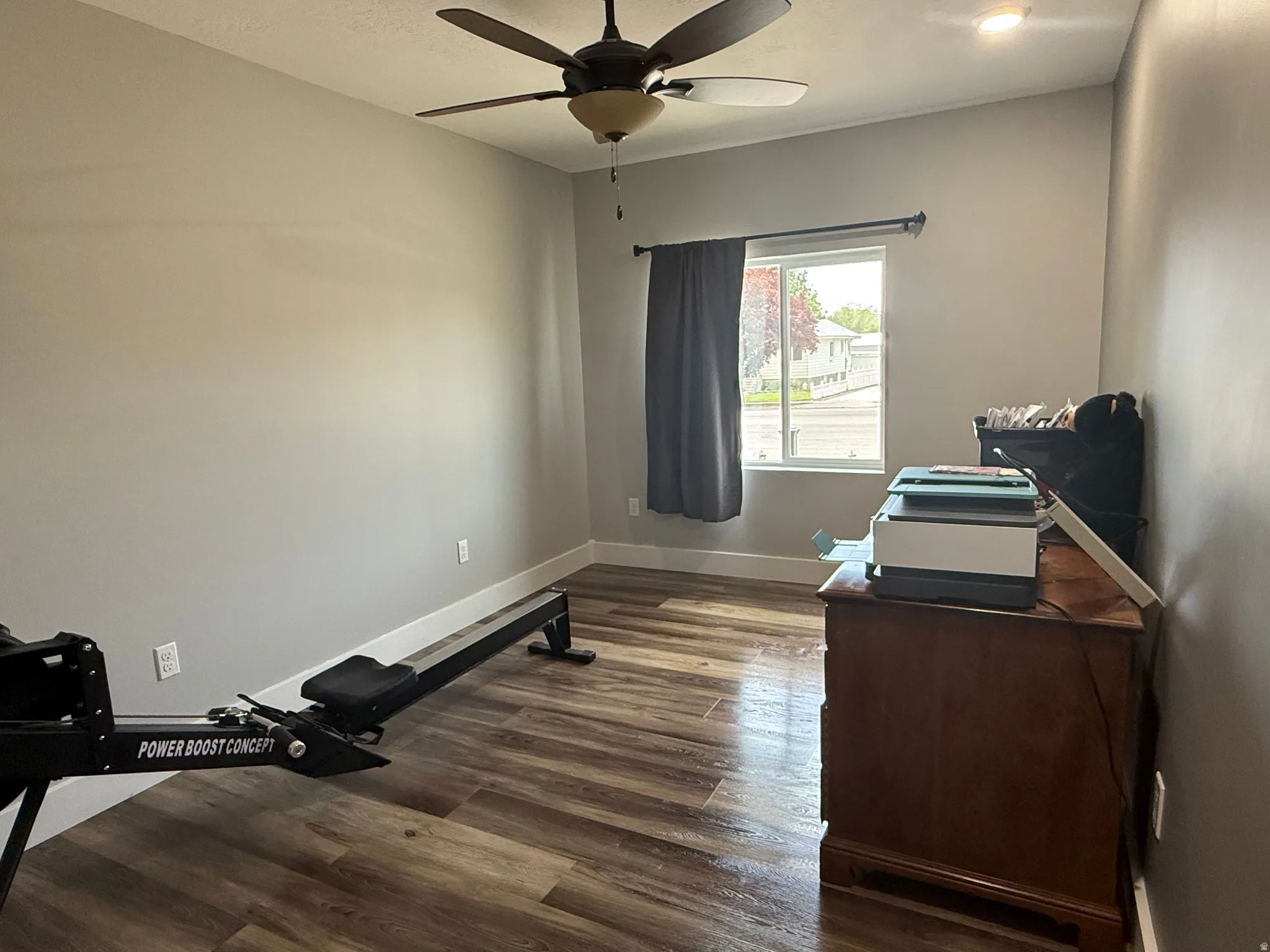 Wood-finish flooring with neutral wall tones and a ceiling fan with integrated lighting