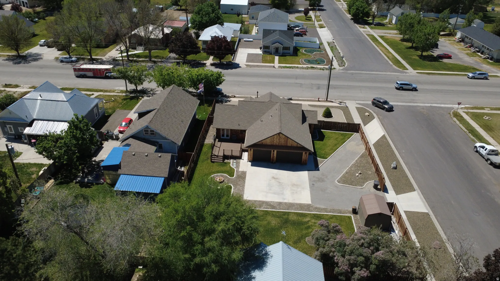 Two-car garage with wood-finish doors, paved driveway, and manicured landscaping
