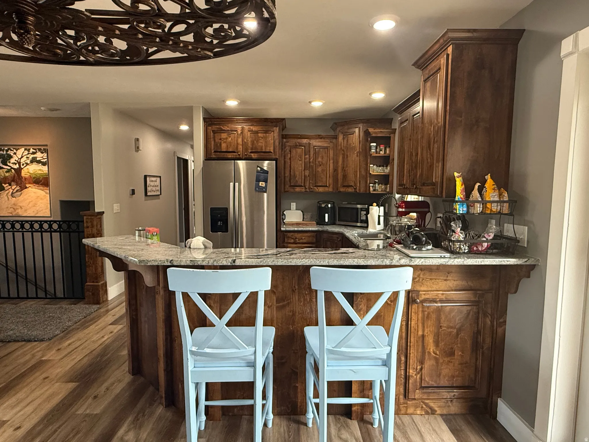 Kitchen featuring wood-finish flooring, recessed lighting, and rich wood cabinetry with crown molding