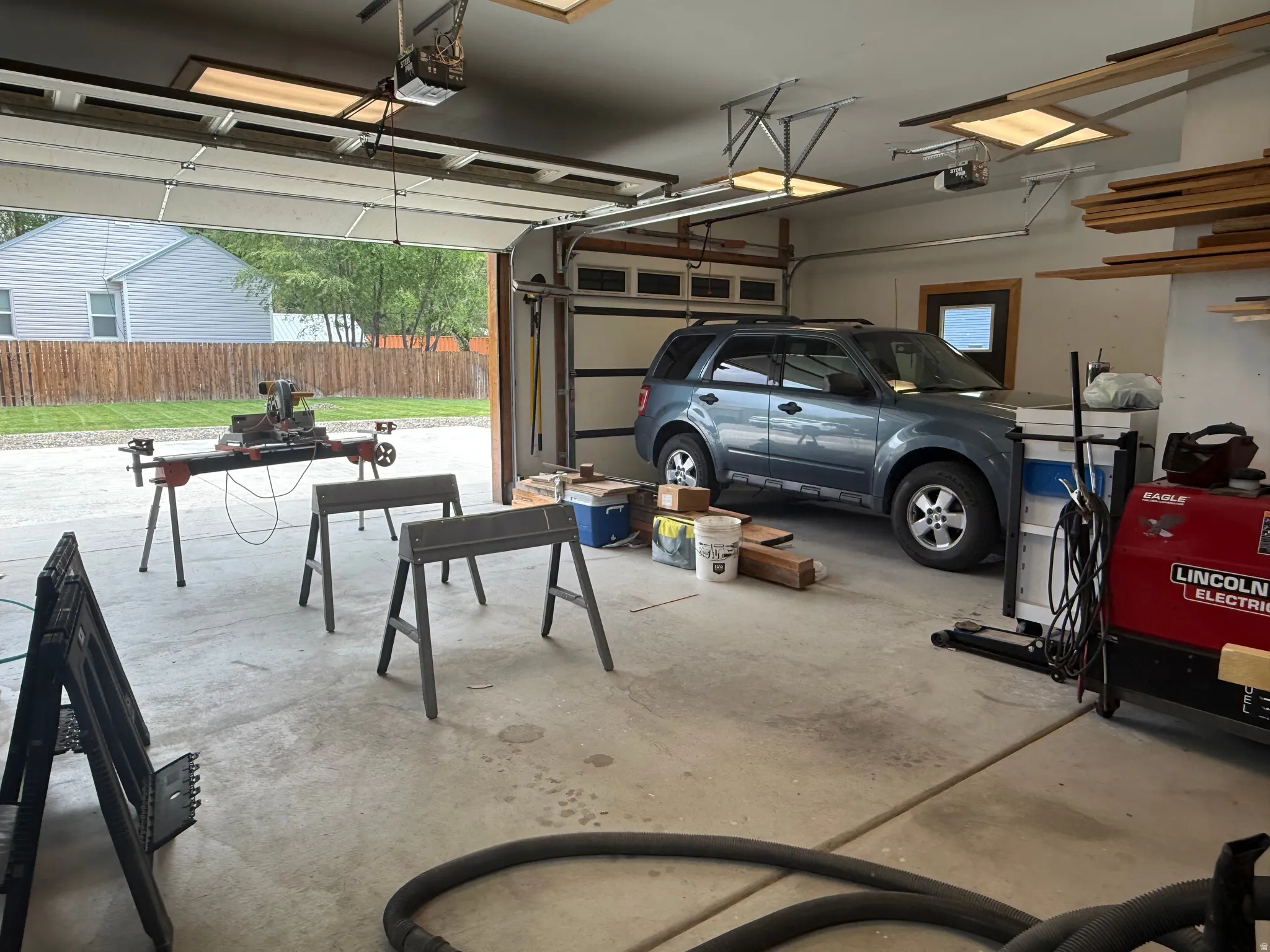 Spacious garage featuring a concrete floor, overhead lighting, and an automatic garage door opener
