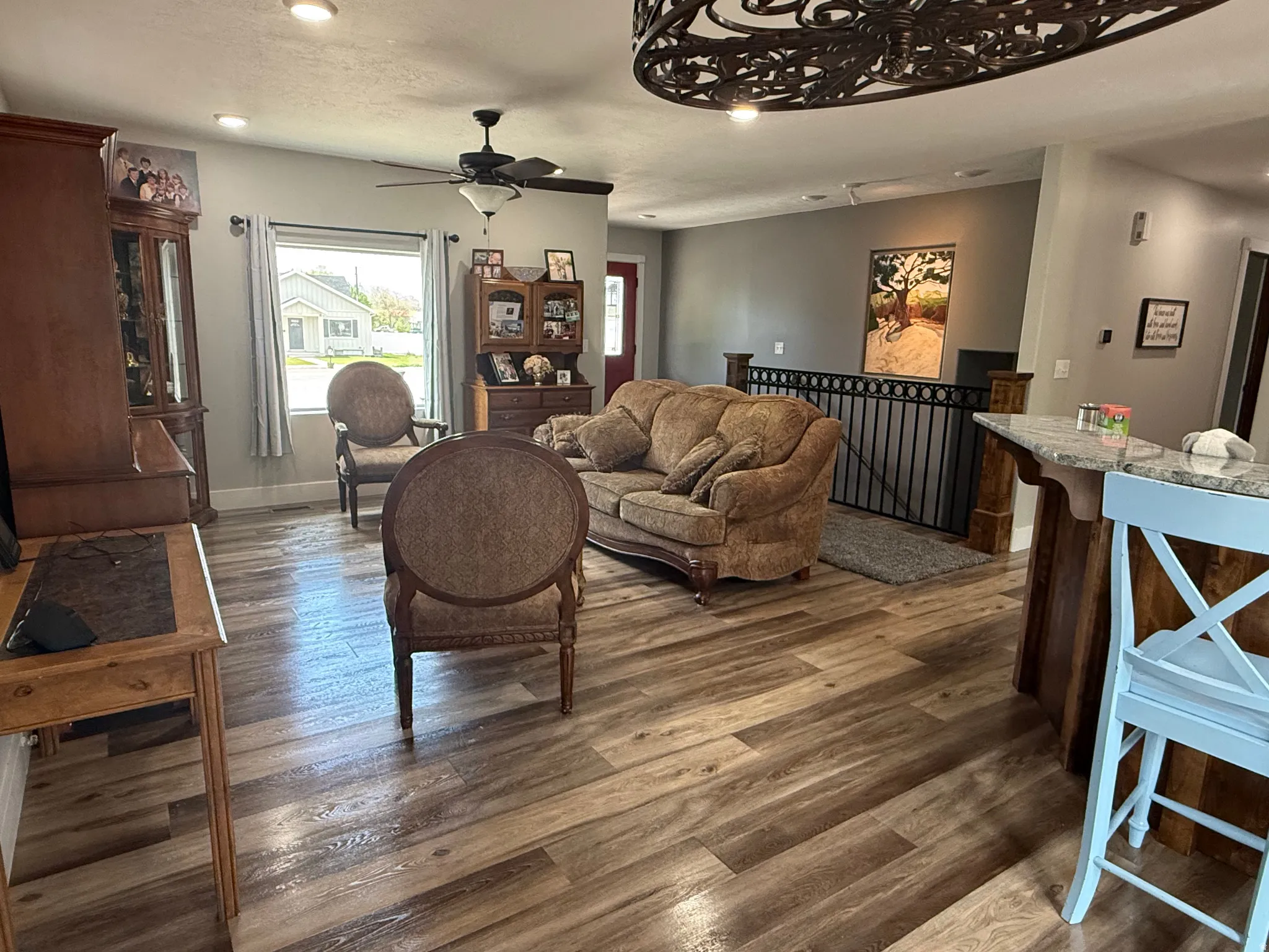 Wood-finish flooring, recessed lighting, ceiling fan, and a built-in bar with a light-colored countertop