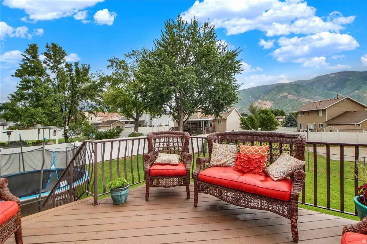 Spacious composite deck featuring composite decking material, black metal railings, and built-in seating with red cushions