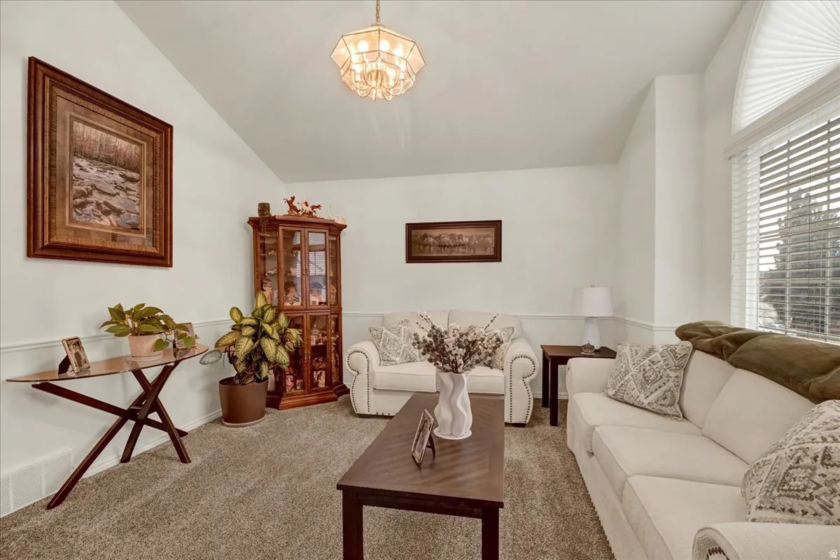 Bright, light-filled living room featuring cream upholstered seating, wood-finish flooring topped with neutral area rugging, and a wood coffee table