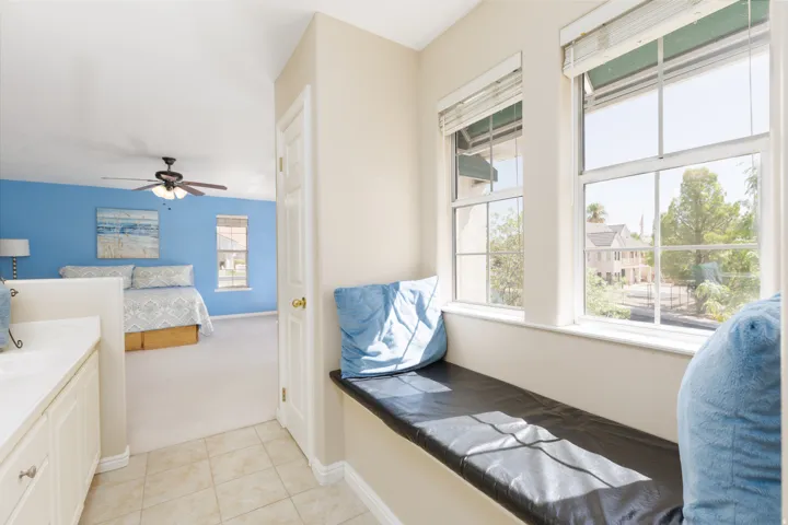 Built-in window bench, double-hung windows, tiled flooring, built-in cabinetry, and ceiling fan