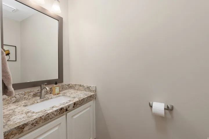 Vanity with a speckled countertop, undermount sink, and brushed nickel faucet