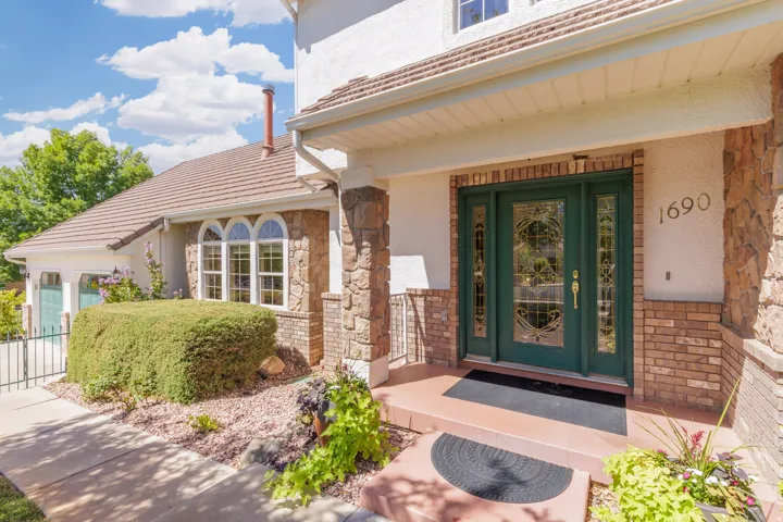 Crafted stone and brick facade with a prominent entry door featuring decorative glass