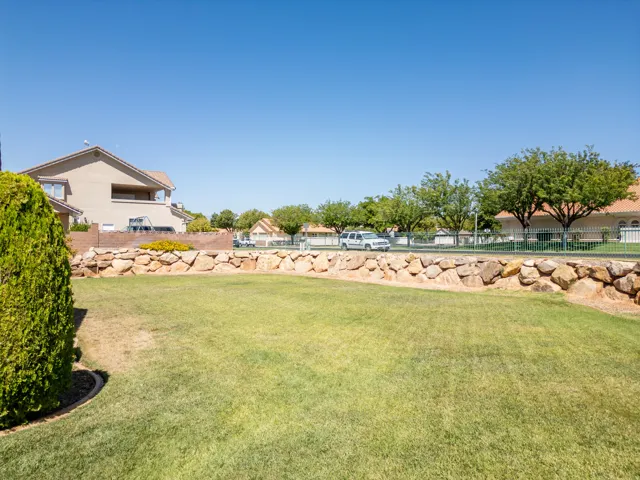 Expansive lawn area bordered by a natural stone retaining wall