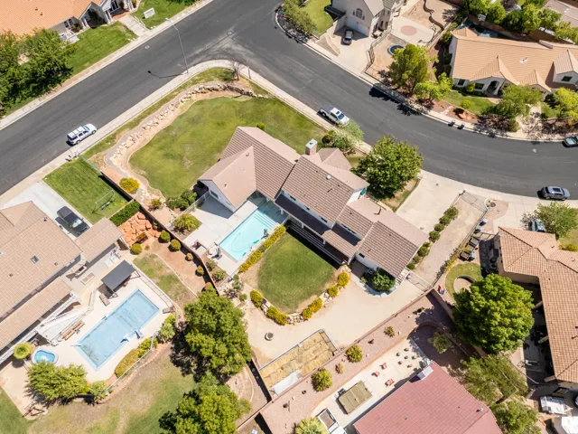 Exterior with a private swimming pool, expansive lawn, mature landscaping, and an attached garage