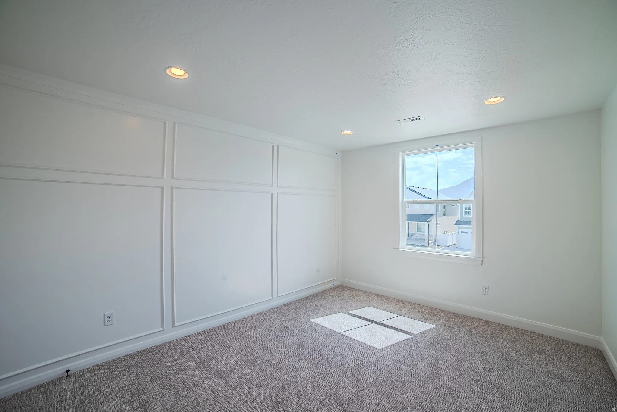 Recessed lighting, wall paneling, window with trim, plush carpet, and crown molding