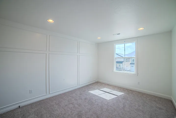 Recessed lighting, wall paneling, window with trim, plush carpet, and crown molding