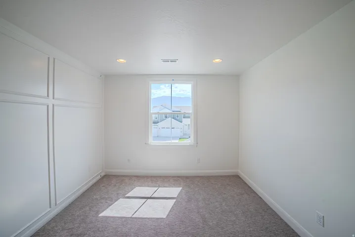 Crisp white walls, recessed ceiling lighting, and a single window offering a clear exterior