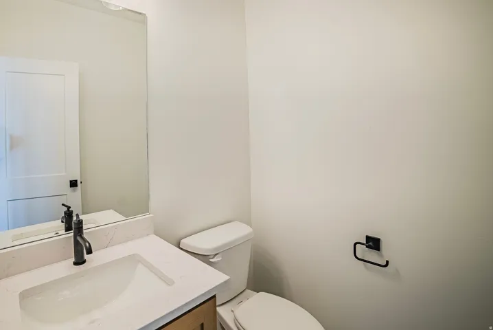 White vanity with an integrated sink, quartz countertop, and black matte faucet
