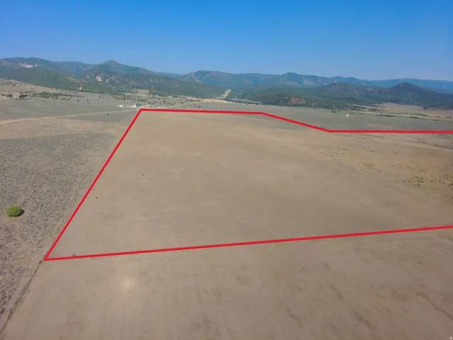 Expansive land parcel featuring clear boundaries and distant mountain scenery