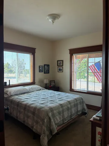 Carpeted room featuring multiple windows with wood trim and horizontal blinds