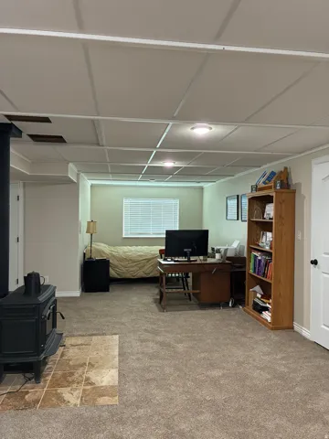Carpeted room featuring a drop ceiling with recessed lighting