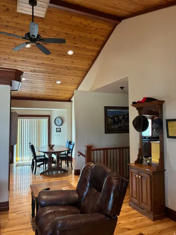 Vaulted wood-paneled ceiling with recessed lighting and ceiling fan