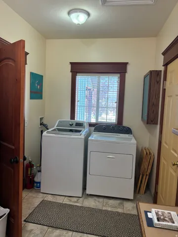 Tile flooring, wood-framed window, overhead lighting, wood panel door, wall-mounted cabinetry
