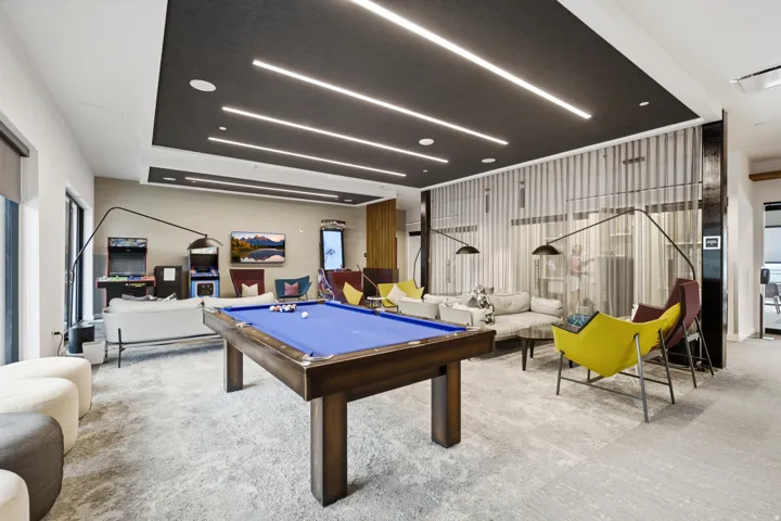 Spacious recreation area featuring a billiards table, recessed lighting, and a textured accent wall