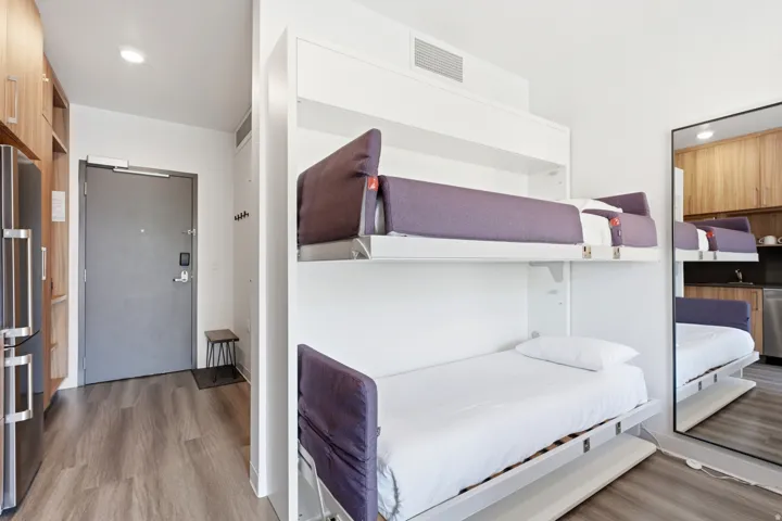 Wood-finish flooring throughout, integrated wall beds, recessed lighting, and built-in shelving