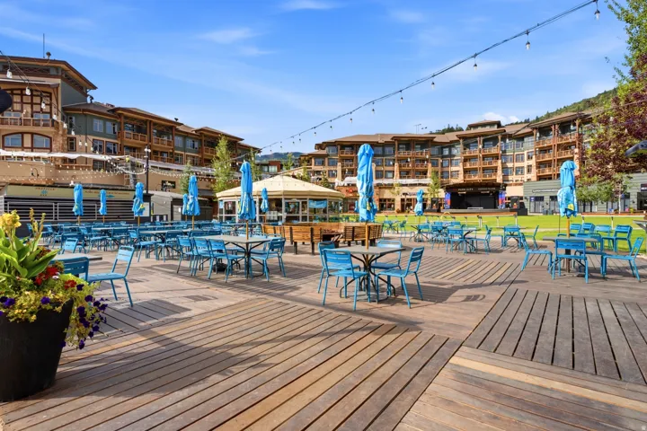 Expansive outdoor plaza featuring wood decking and a manicured lawn
