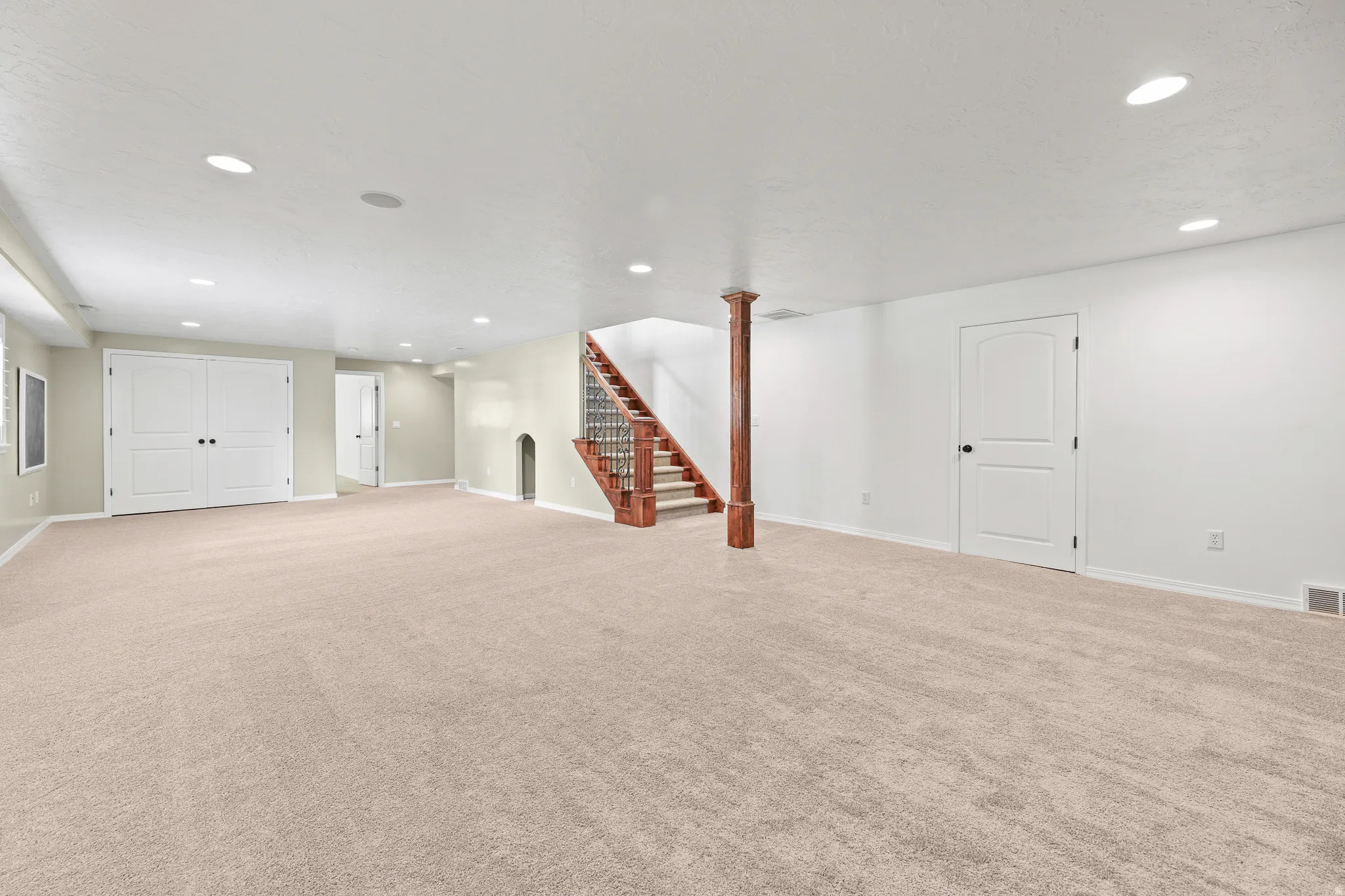 Spacious room with light-toned carpeting and recessed lighting