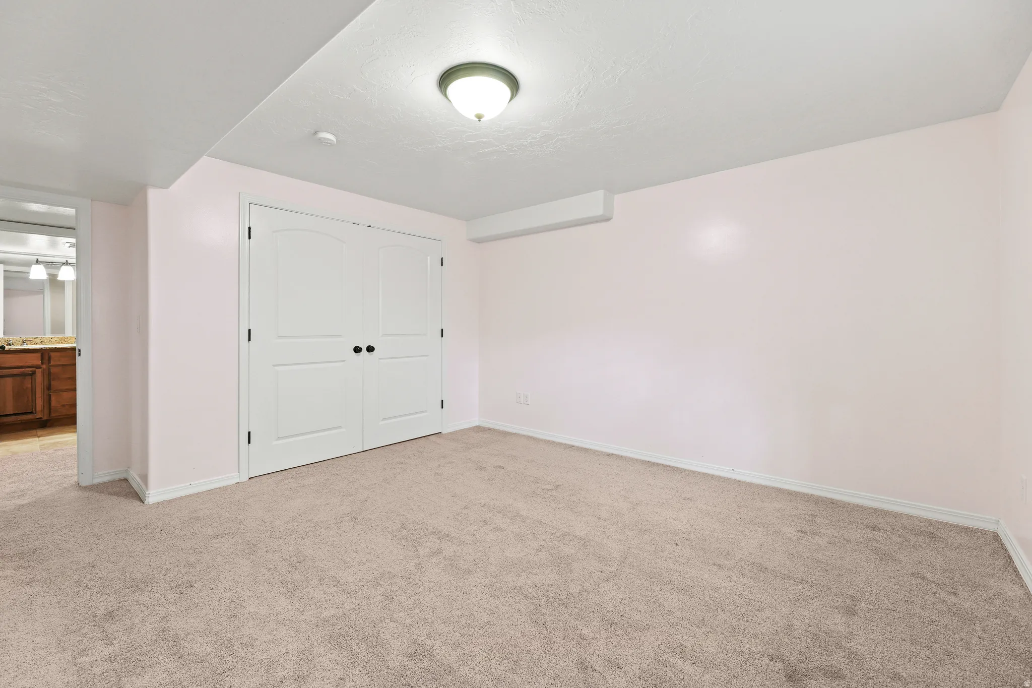 Neutral-toned carpeting paired with light pink walls