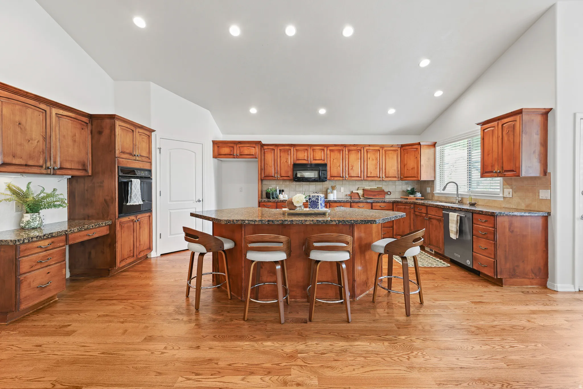 Vaulted ceilings, recessed lighting, wood-finish flooring, wood cabinetry, and an integrated oven