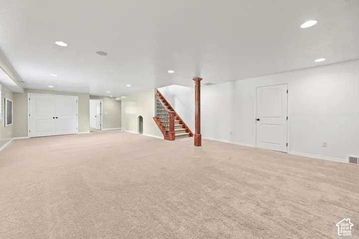 Spacious room with light-toned carpeting and recessed lighting