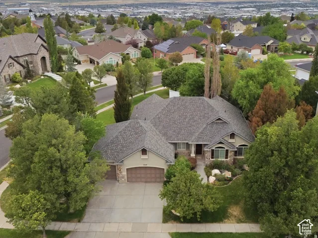 Pitched roofline, mature trees, multi-pane windows, and an attached two-car garage