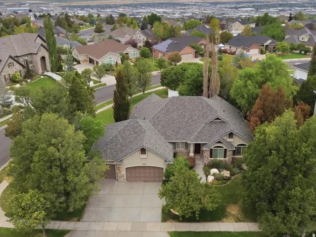 Pitched roofline, mature trees, multi-pane windows, and an attached two-car garage