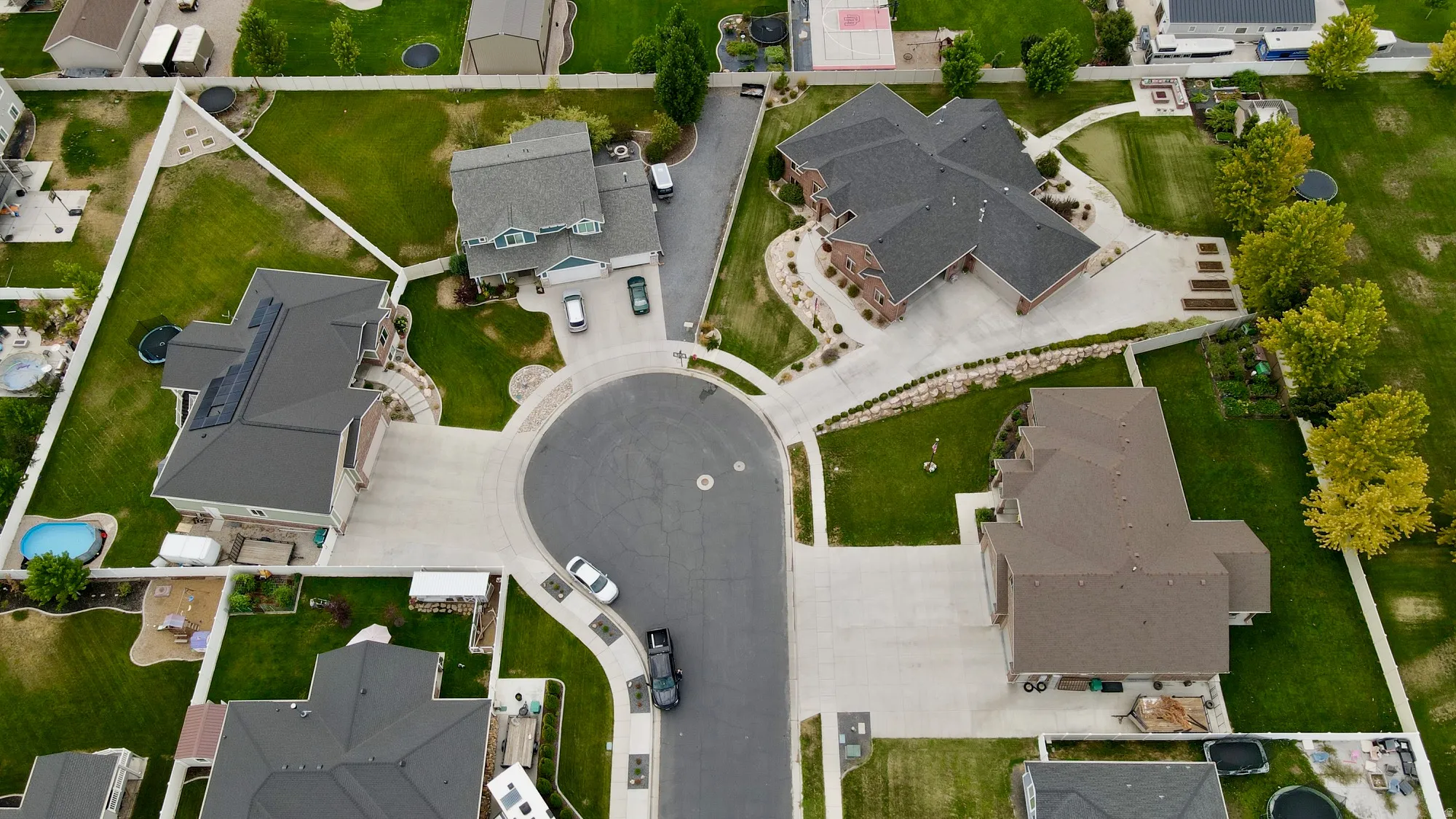 Cul-de-sac location with multiple properties featuring mature landscaping, paved driveways, and expansive green spaces