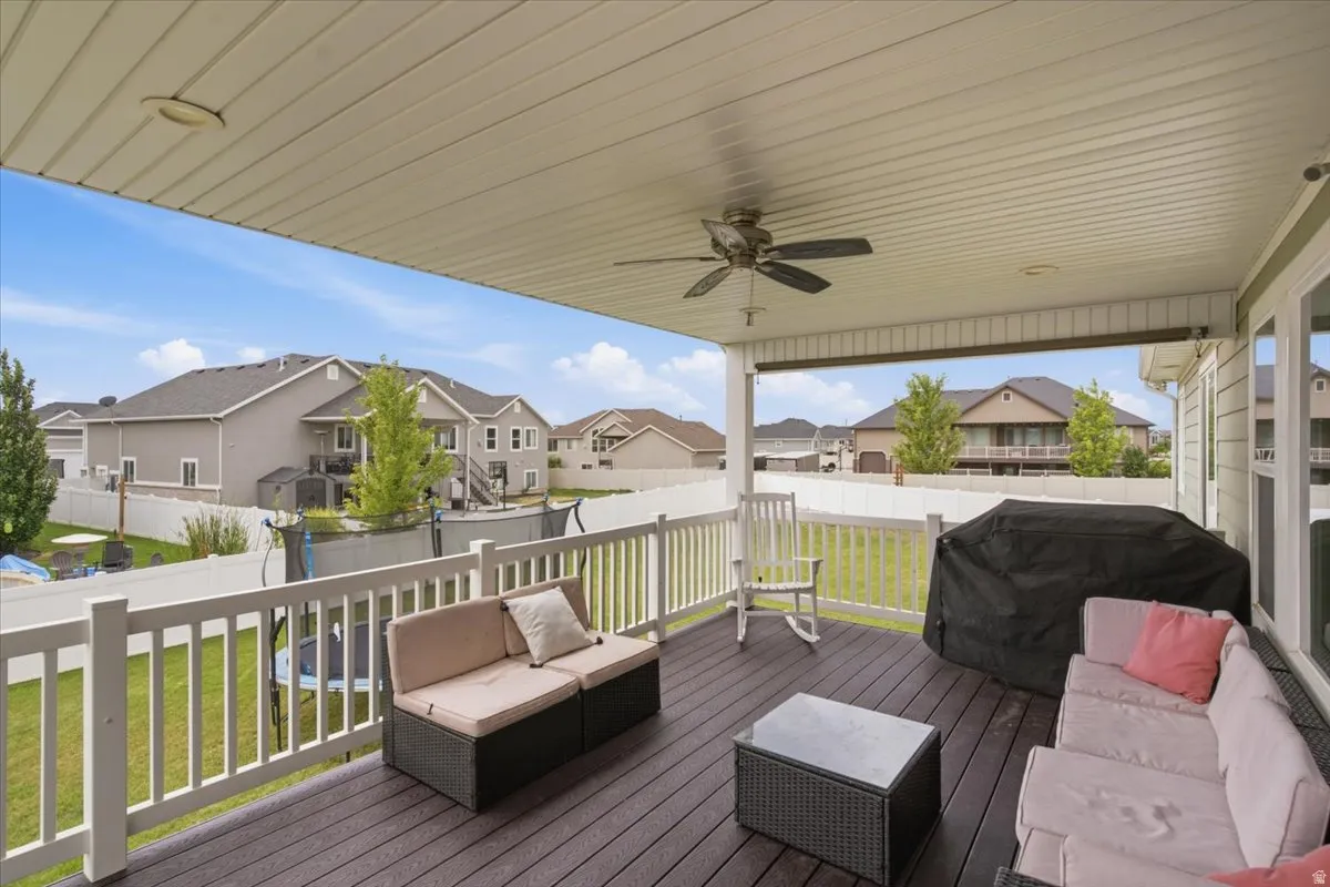 Expansive composite deck featuring composite decking, white vinyl railings, and a ceiling fan beneath a covered structure