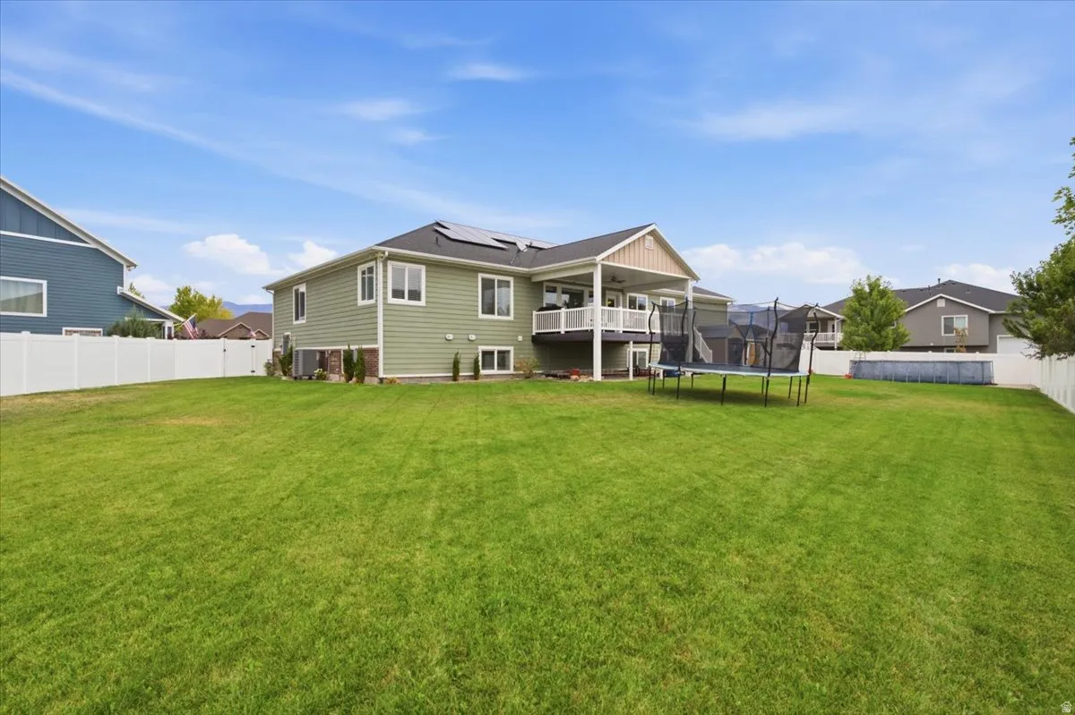 Expansive green lawn with a white privacy fence
