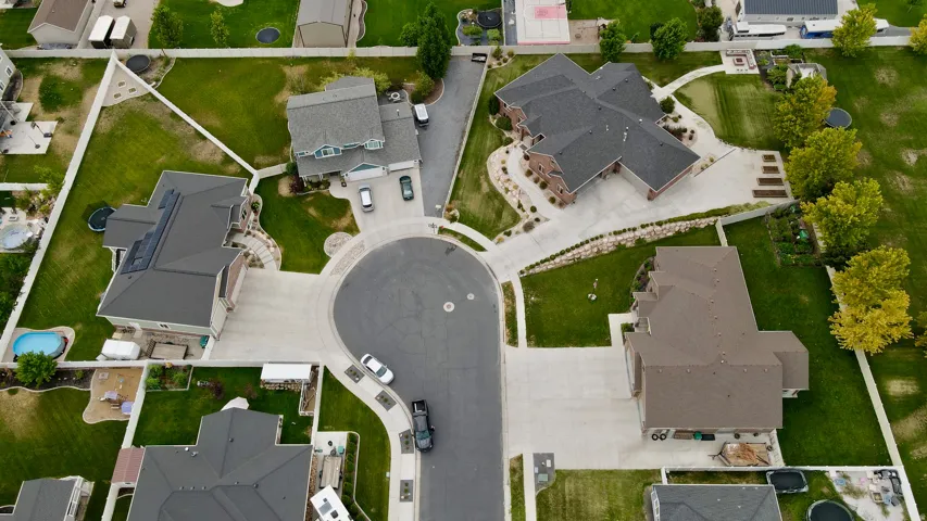 Cul-de-sac location with multiple properties featuring mature landscaping, paved driveways, and expansive green spaces