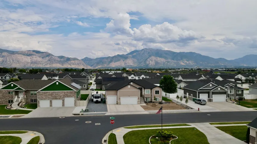Residential neighborhood featuring a variety of single-family homes, paved streets, and mountainous terrain in the background