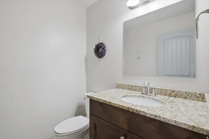 Elegant bathroom vanity featuring a rich wood-finish cabinet, granite-topped countertop with integrated sink, and polished chrome faucet