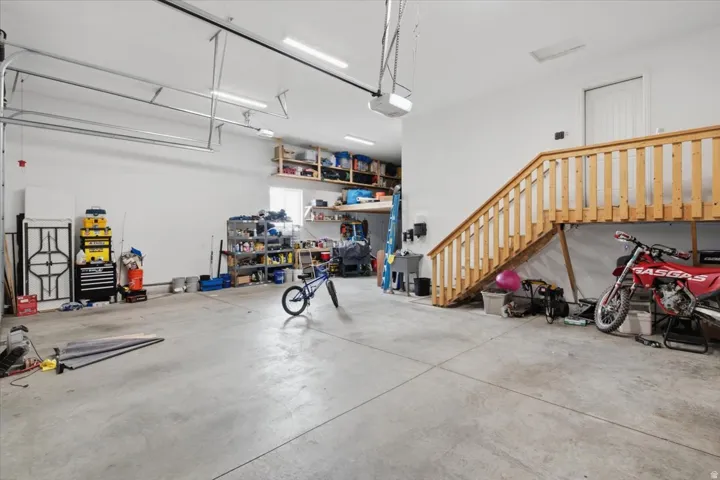 Spacious garage with polished concrete flooring, overhead lighting, and ample storage shelving
