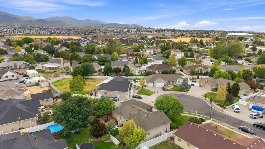 Residential community with extensive mature landscaping, varied rooflines, and mountain scenery
