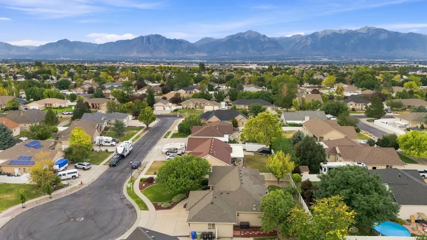 Residential neighborhood with mature trees and mountain backdrop