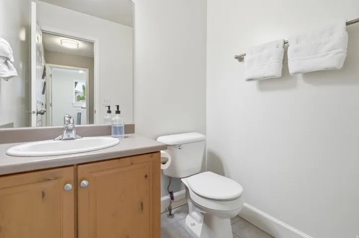 Vanity with wood-finish cabinetry, integrated sink, and chrome faucet
